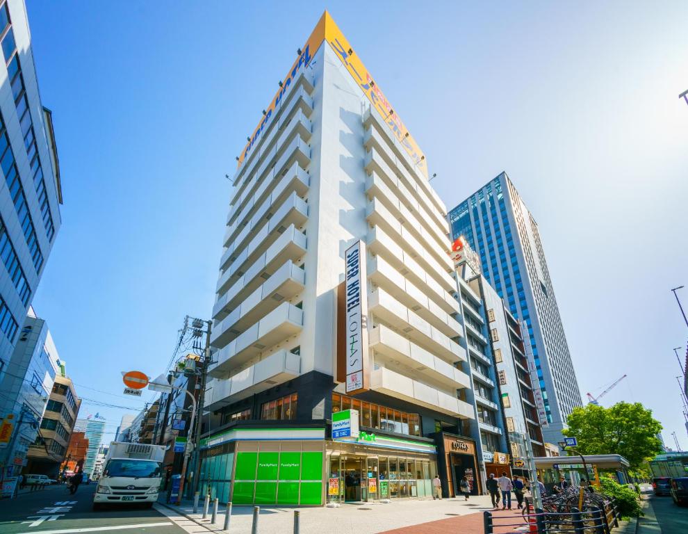 大阪Super Hotel Premier Osaka Honmachi Ekimae Natural Hot Springs的城市街道上一座高大的建筑,有建筑