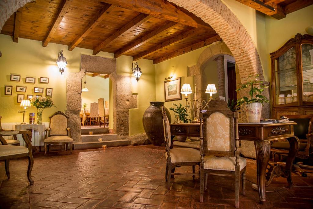 特鲁希略波萨达欧力拉斯精品酒店的客厅配有椅子、桌子和镜子