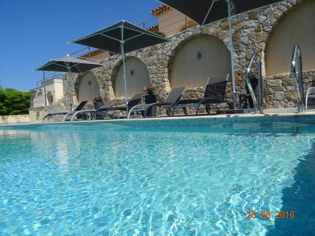 卢米奥海宁别墅酒店的一个带椅子和遮阳伞的大型游泳池
