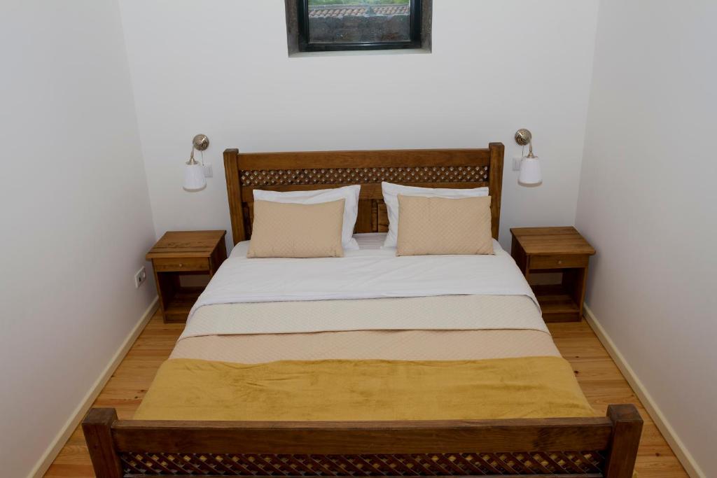 马达莱纳O Farrobo的一间卧室配有一张大床和两张桌子