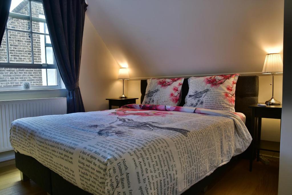 豪达Tannery Lane的一间卧室配有一张带两盏灯的床和一扇窗户。
