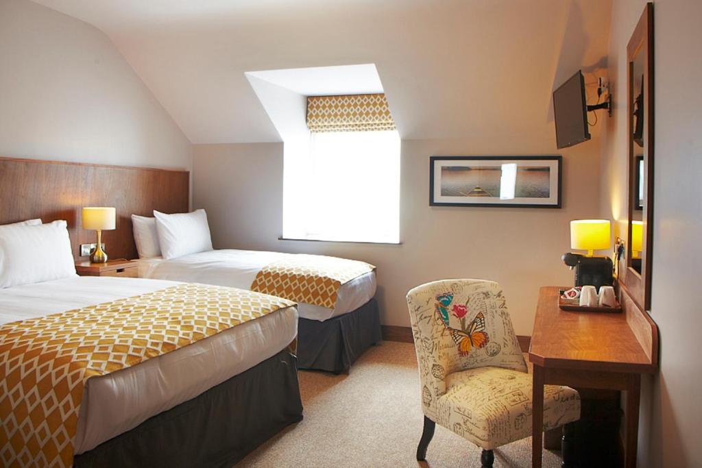 班克洛迪Clody Lodge的一间卧室配有两张床、一张桌子和一把椅子