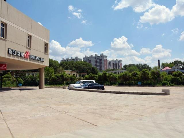 四平锦江之星四平平东大路万达广场酒店的停在大楼旁边的停车场的汽车