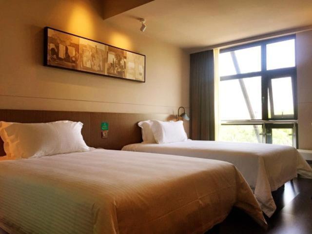 南汇锦江之星品尚上海国际旅游度假区惠南野生动物园酒店的酒店客房设有两张床和窗户。