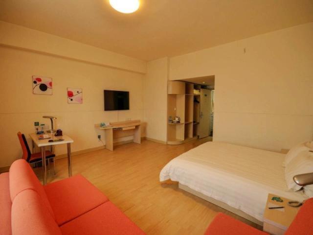 西宁锦江之星西宁五四西路师范大学酒店的一间卧室配有一张床、一张桌子和一张沙发