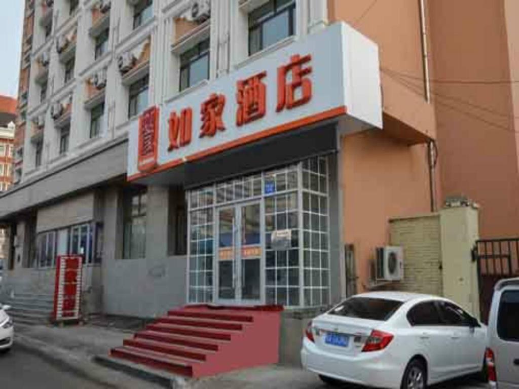 哈尔滨如家快捷酒店哈尔滨西大直街工大店的停在大楼前的白色汽车