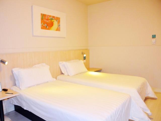 石家庄锦江之星石家庄联盟路酒店的配有白色床单的酒店客房内的两张床