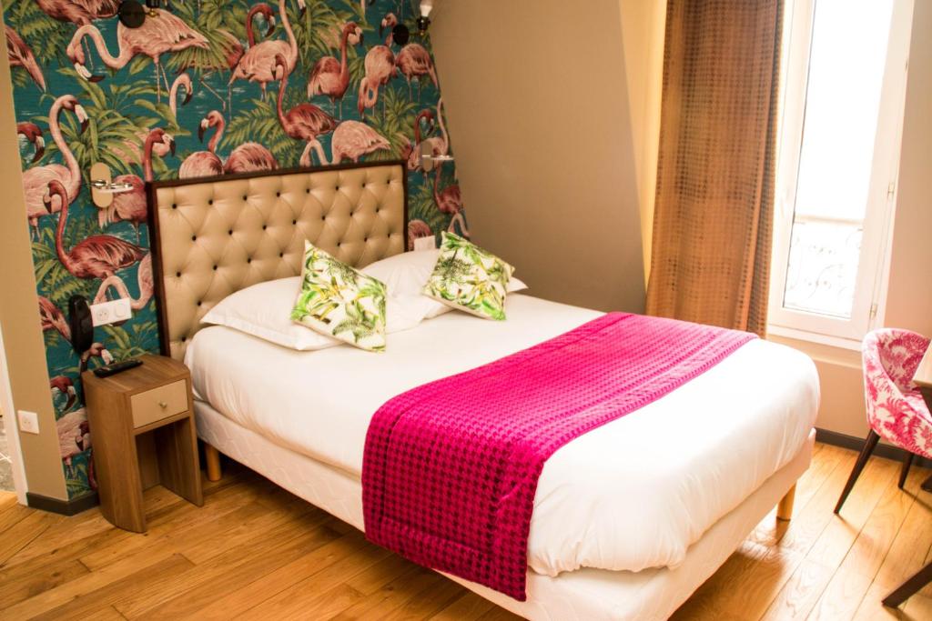 巴黎巴蒂尼奥勒埃克塞尔西奥酒店的一间卧室配有一张带粉色毯子的床