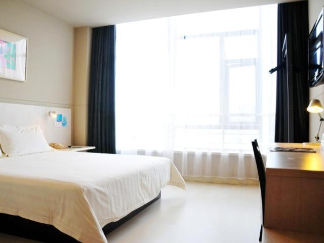 苏州锦江之星吴江中山北路步行街酒店的一间卧室配有一张床、一张书桌和一个窗户。