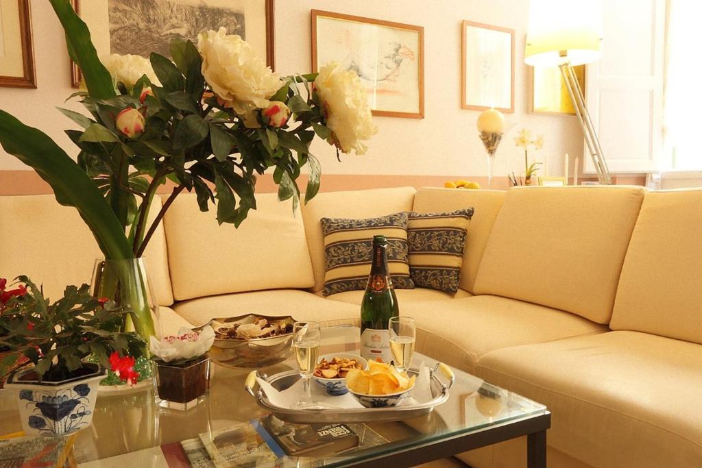 佛罗伦萨巴迪亚佛罗伦萨酒店的客厅配有沙发和一张带一瓶香槟的桌子