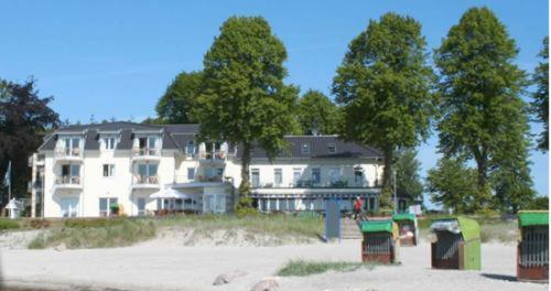 希尔克道夫希尔克道夫酒店的海滩上一座白色的大建筑,树丛繁茂