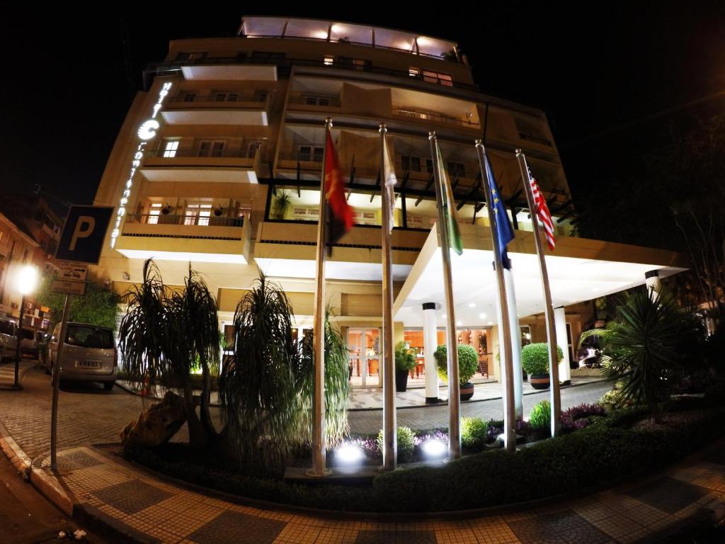 罗安达罗安达大陆酒店的一座在晚上有旗帜的建筑