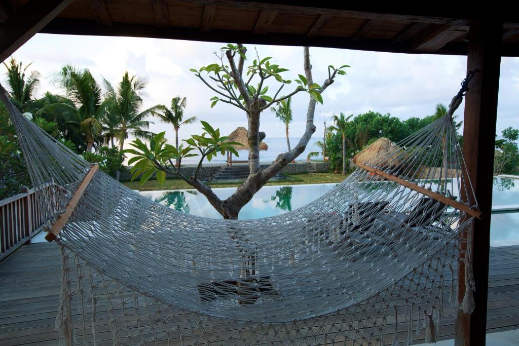 艾湄湾甘榜别墅的游泳池旁门廊上的吊床