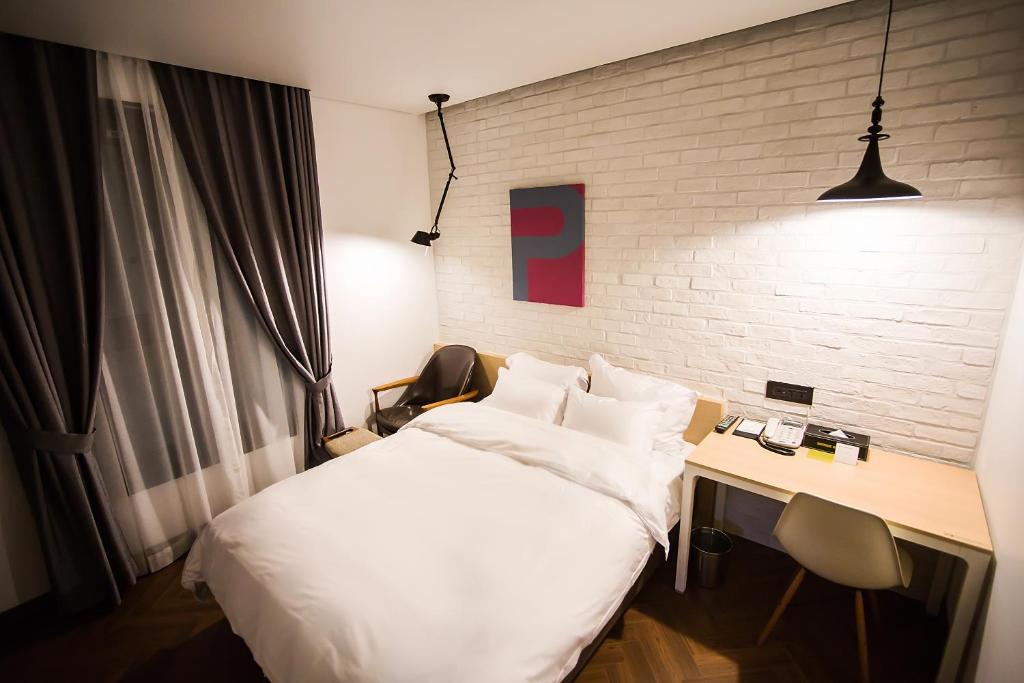 光州葡萄酒精品酒店的酒店客房设有一张床和一张书桌,