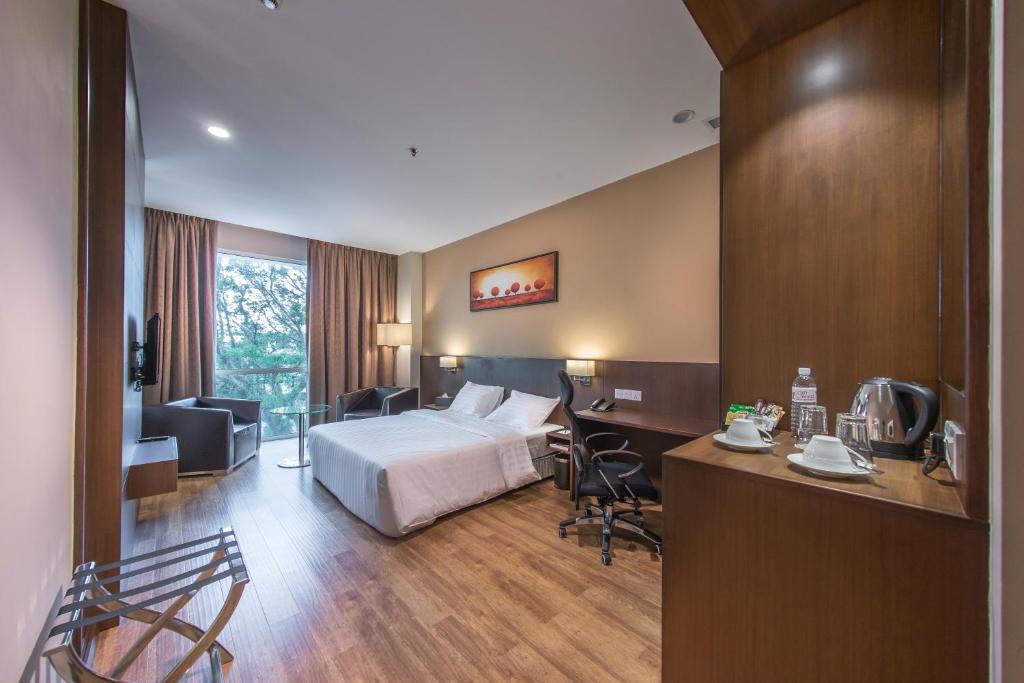 Kuala Belait奇奥加酒店的配有一张床和一张书桌的酒店客房
