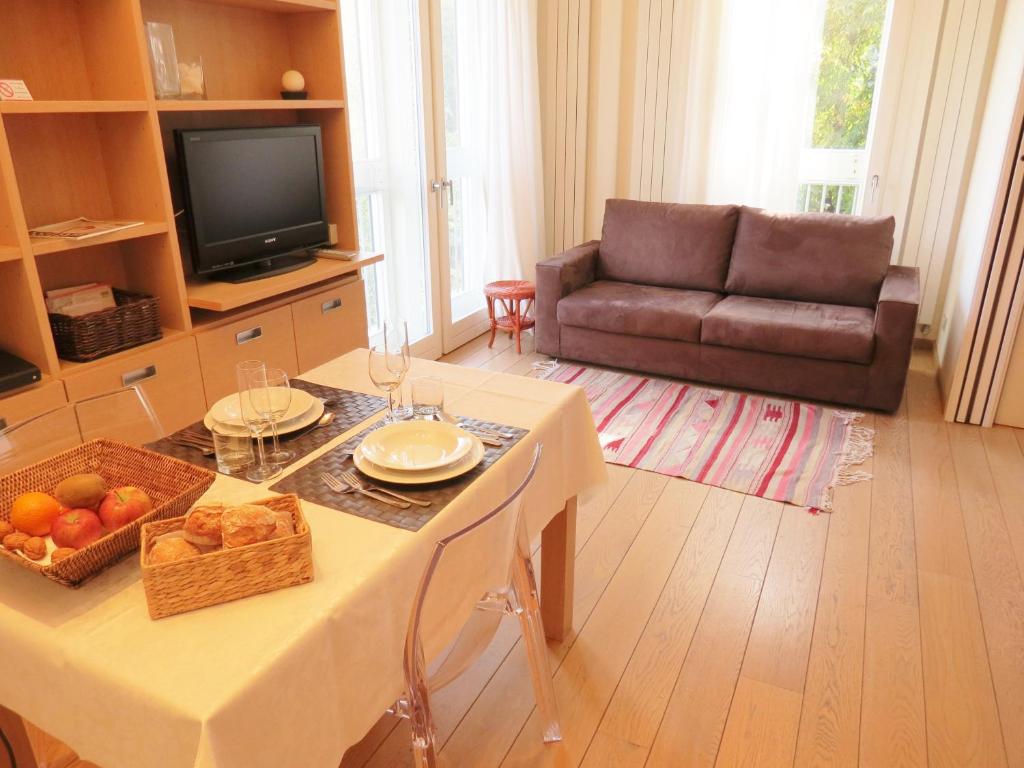 米兰贝利萨里奥费拉米兰诺公寓的客厅配有桌子和沙发