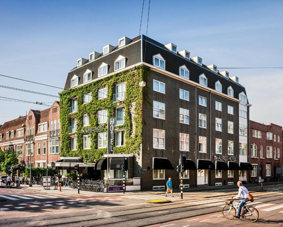 阿姆斯特丹阿尔弗雷德酒店的在建筑物前骑车的人
