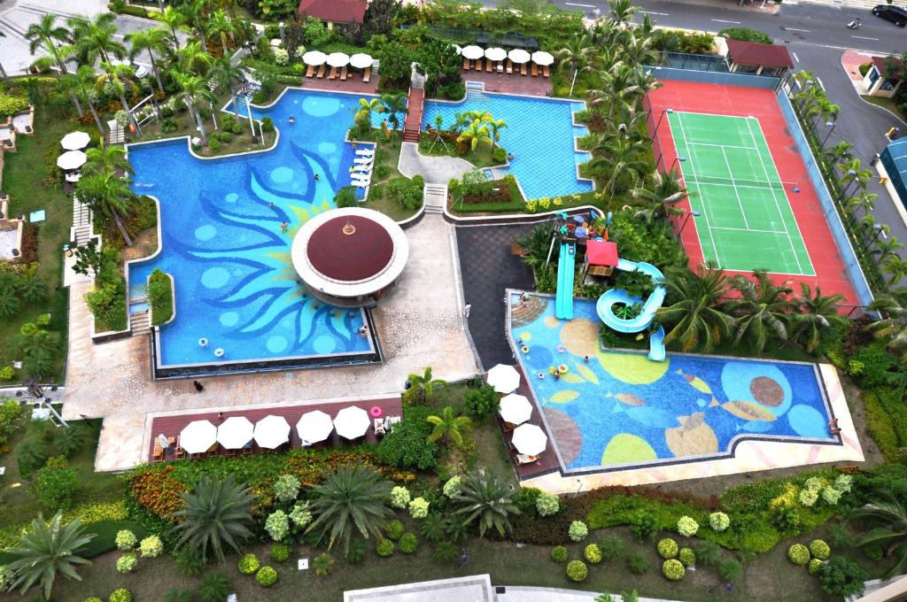 三亚三亚一克海酒店式公寓的享有度假村游泳池的顶部景致