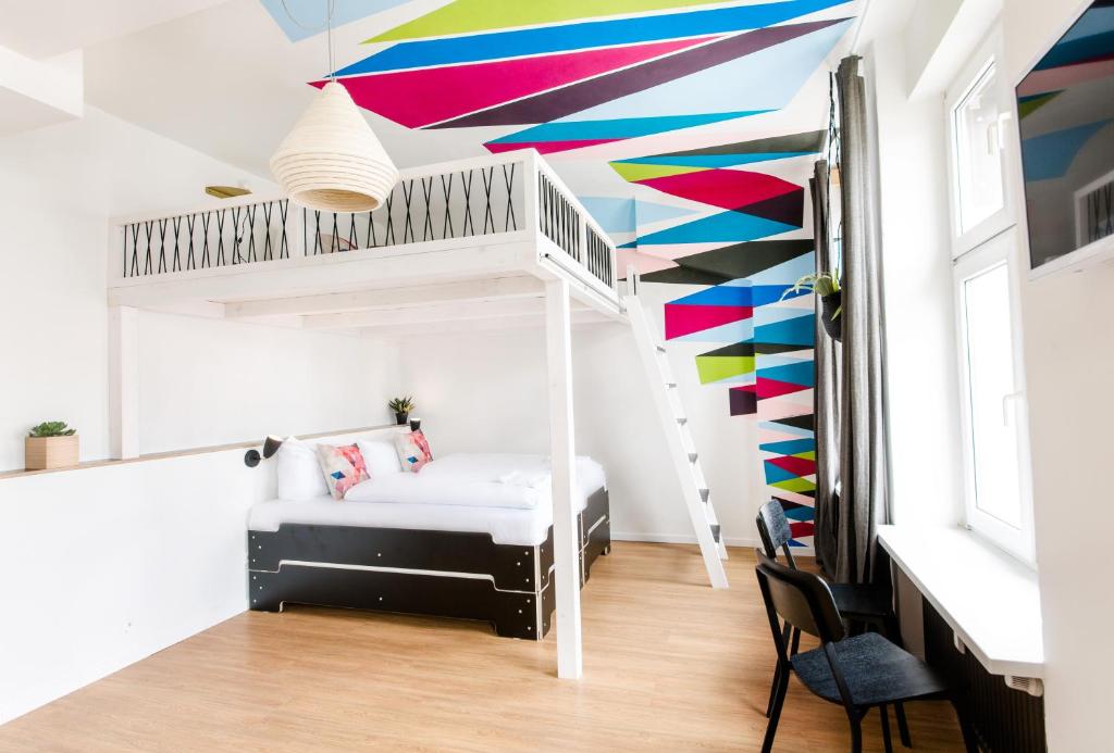 汉堡善珍夫特尔睡衣公园酒店的一间卧室设有一张双层床,拥有色彩缤纷的天花板