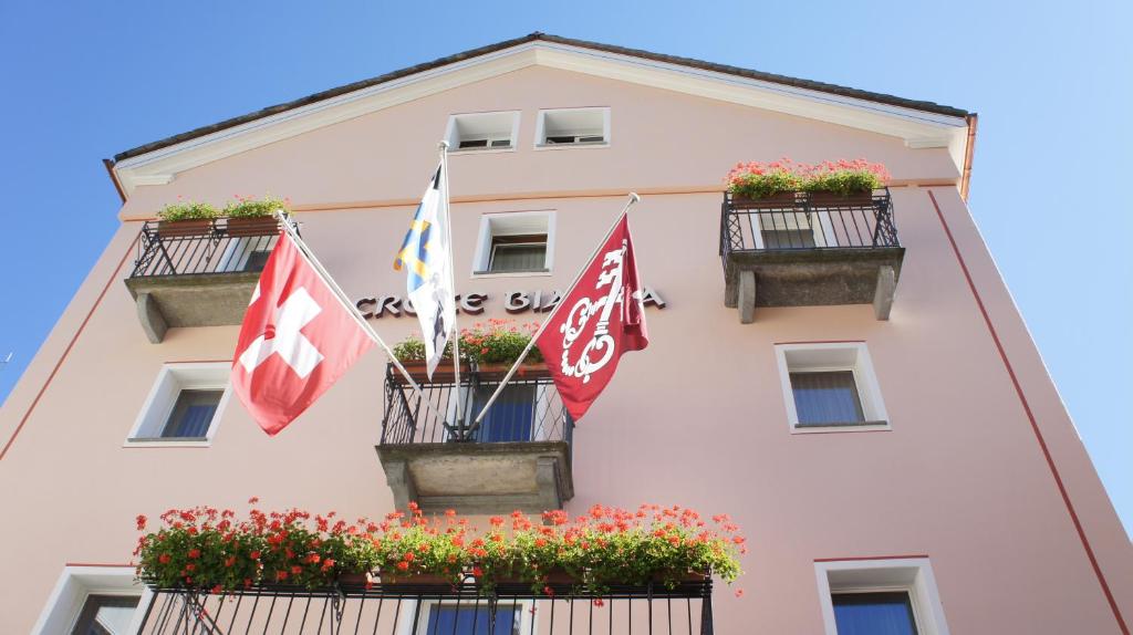 波斯基亚沃克洛斯比安卡酒店的前面有旗帜和鲜花的建筑