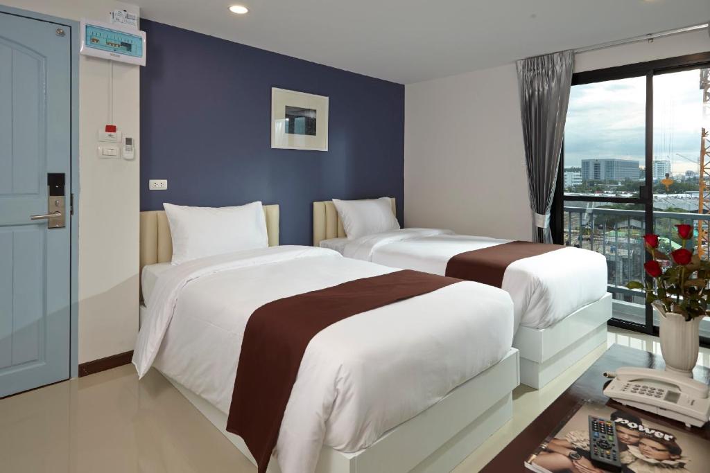 曼谷卡萨酒店的配有窗户的酒店客房内的两张床
