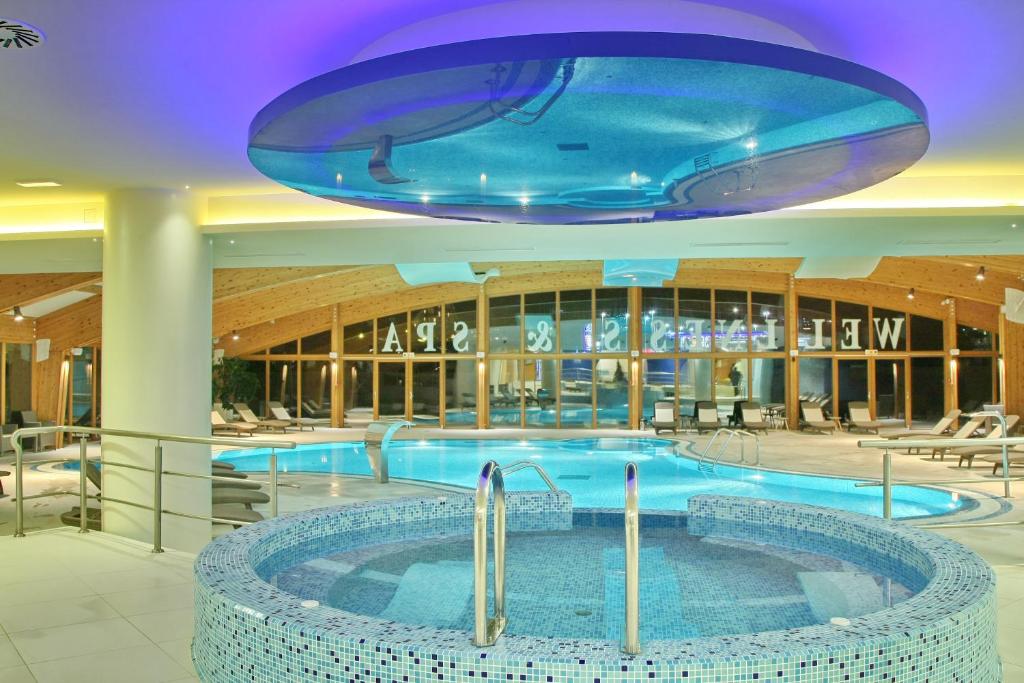 兹拉蒂博尔奥林普酒店的蓝色天花板建筑中的一个大型游泳池