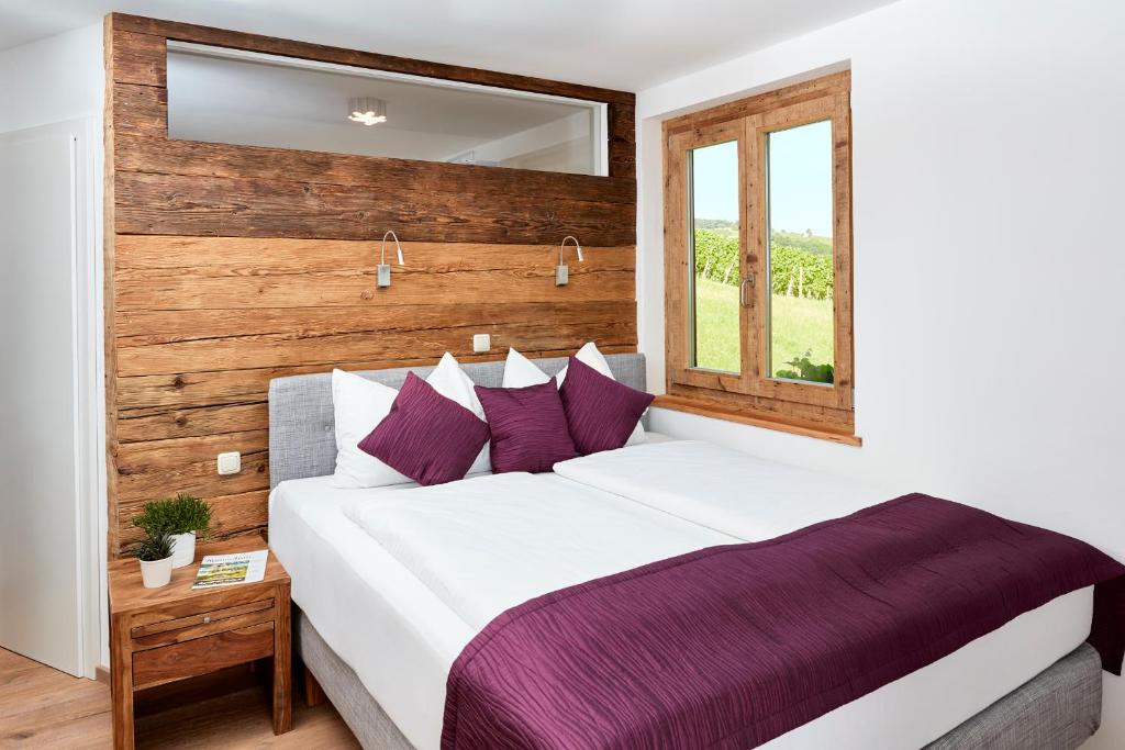 克勒希Weinberg Lodge - Kellerstöckl的卧室配有一张带紫色枕头的大型白色床。