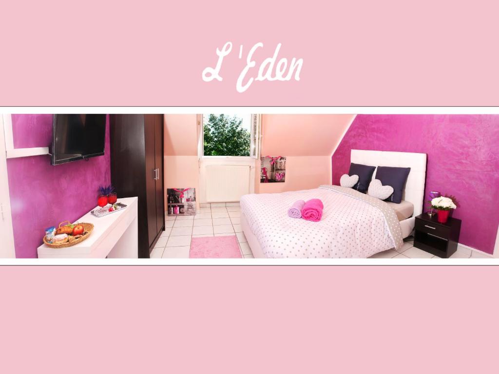 蒂艾L'Eden Orly Aéroport的粉红色的卧室设有一张床和一间厨房