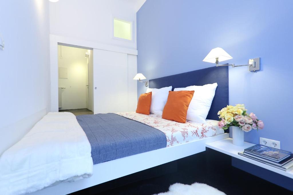 维也纳比穆丽城高级公寓的一间卧室配有一张带橙色枕头的大床
