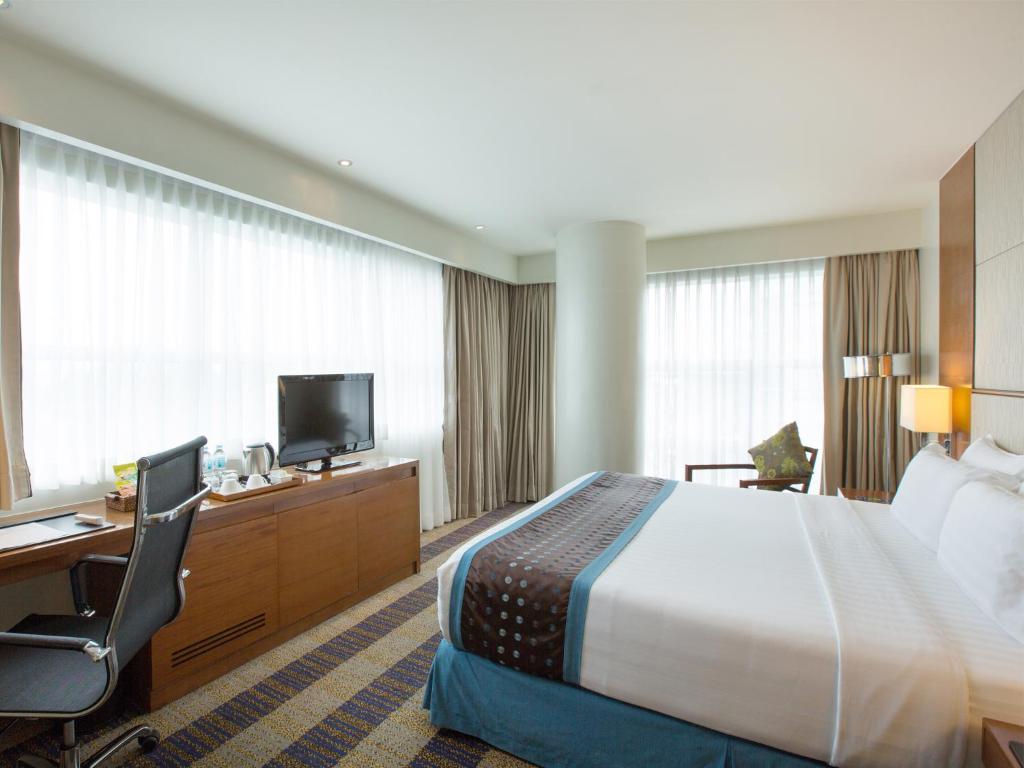 宿务Lex Hotel Cebu的酒店客房配有一张床、一张书桌和一台电视。