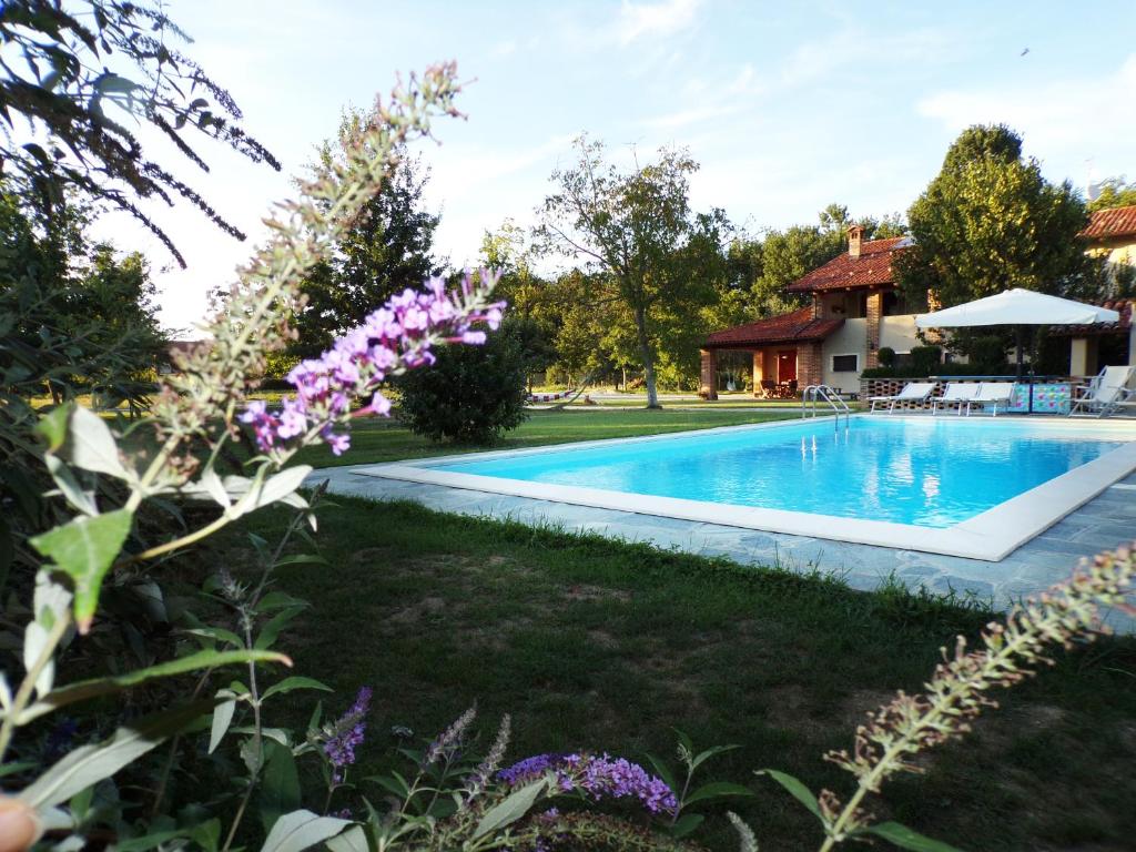 贝内瓦吉恩纳卡利诺住宿加早餐旅馆的一座鲜花盛开的房子的院子内的游泳池