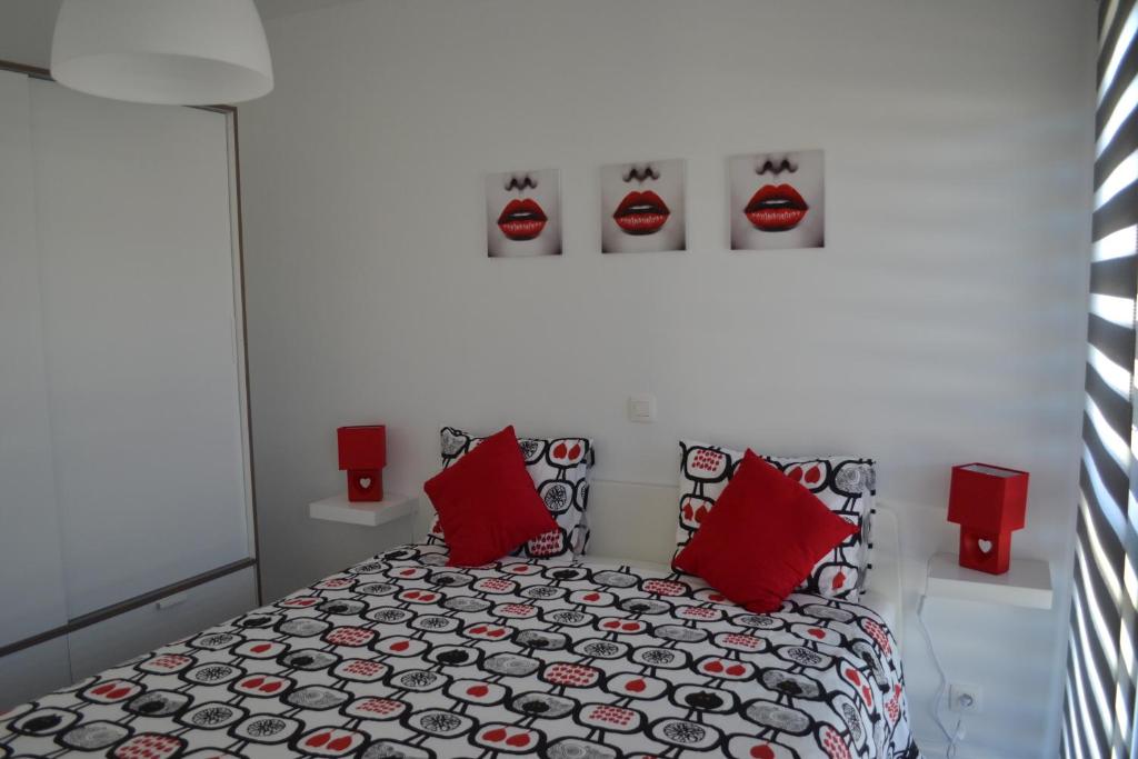 斯塔沃洛La boîte rouge的一间卧室配有红色枕头的床