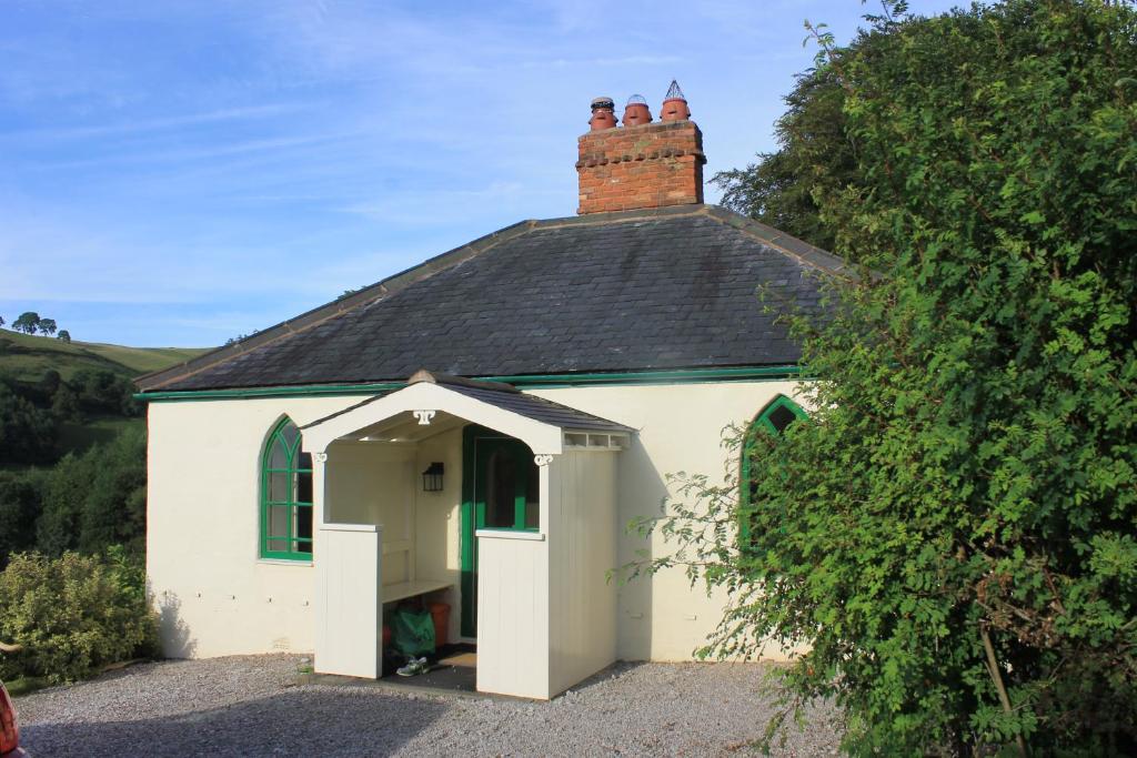 LlandyrnogGlyn Arthur Lodge的一座白色的小建筑,有黑色的屋顶