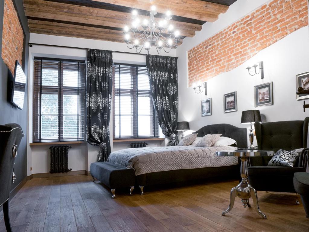 克拉科夫Leonardo 2的一间卧室设有一张床和砖墙