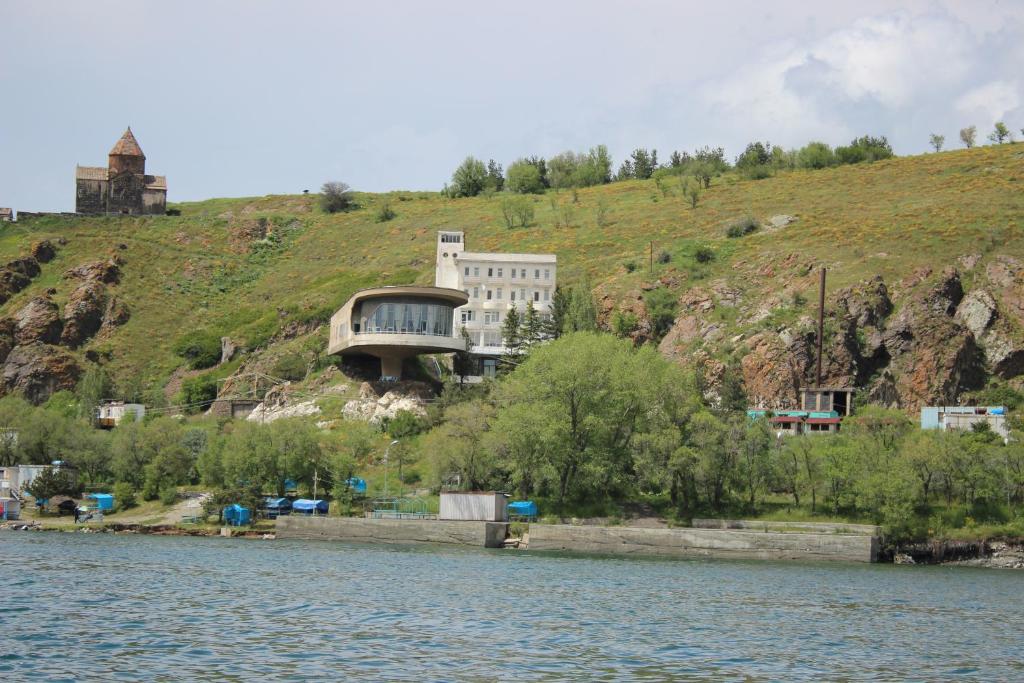 塞凡Sevan Writers House的水体旁山丘上的房屋