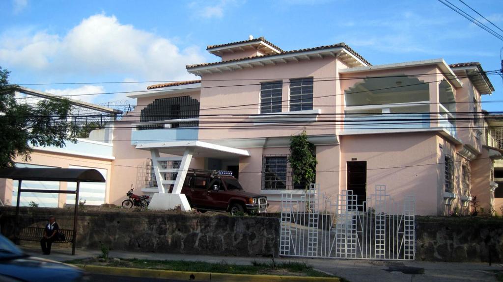 圣萨尔瓦多Hostal Cumbres del Volcan Flor Blanca的一辆停在前面的白色房子,一辆面包车