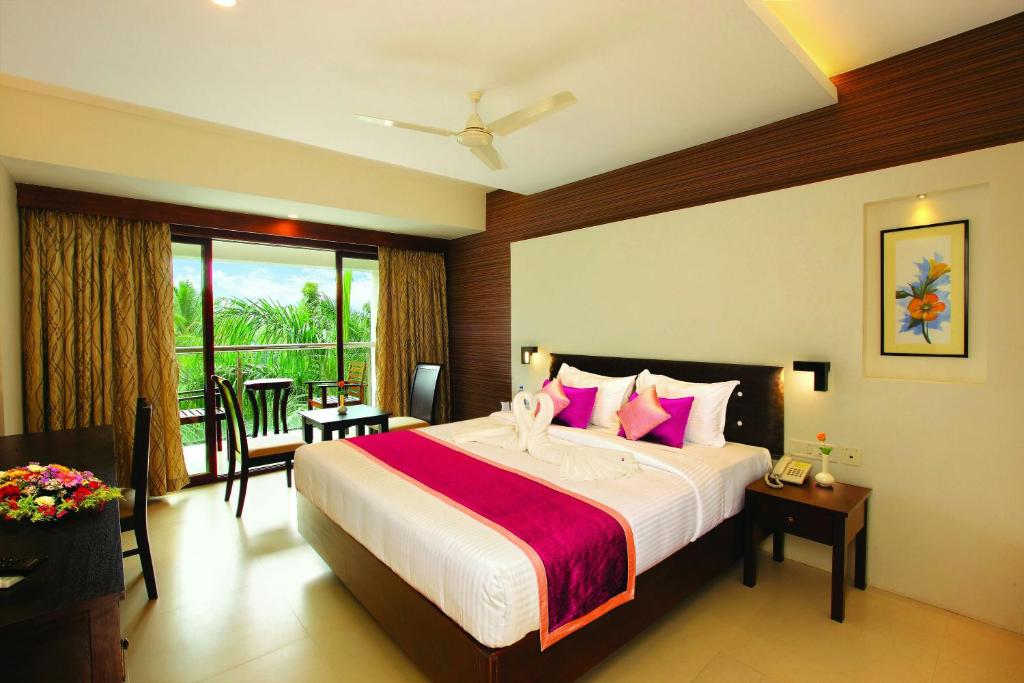 提喀迪Holiday Vista Luxury Hotel and Spa, Thekkady的卧室配有一张带粉红色枕头的大床
