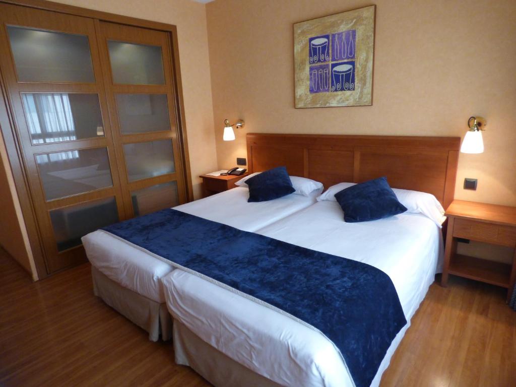 马德里维亚路易斯塔娜生态酒店的酒店客房 - 带两张带蓝色枕头的床