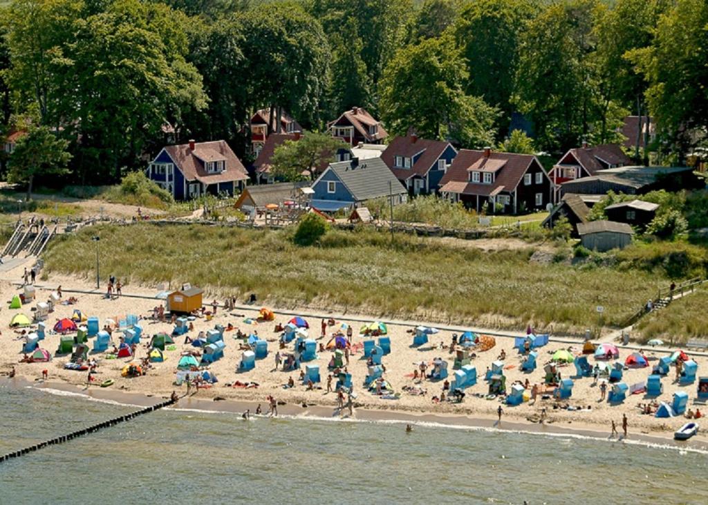 于克里茨SEETELHOTEL Nautic Usedom Dünenhäuser的一群人在海滩上,带遮阳伞