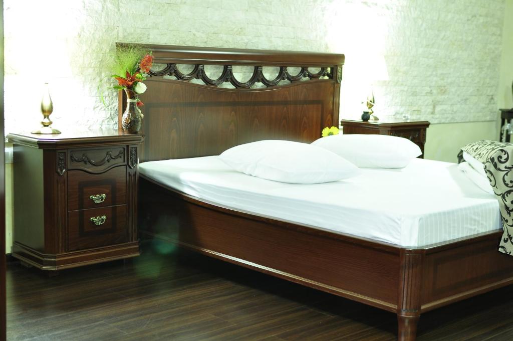 德罗贝塔-塞维林堡Hotel Restaurant Elite的一间卧室配有一张带白色床单和枕头的木制床。