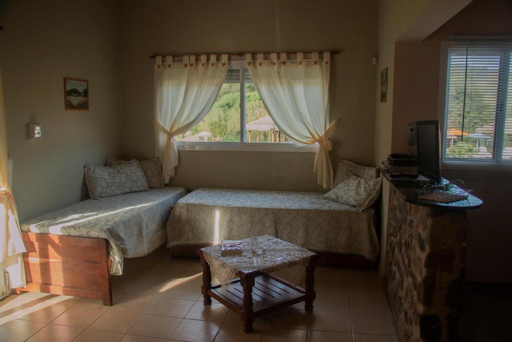 比亚莱特马西Apart Cabañas El Tala的一间带两张床和窗户的客厅