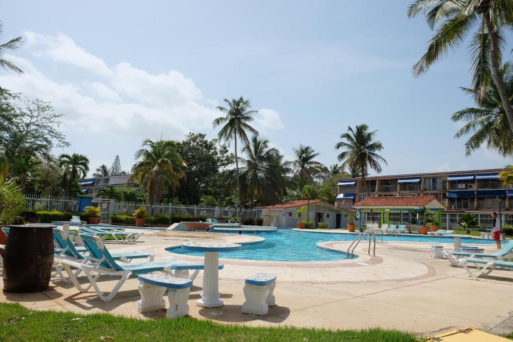 多拉多多拉多帕拉蒂姆别墅的一个带躺椅的游泳池,一个度假村
