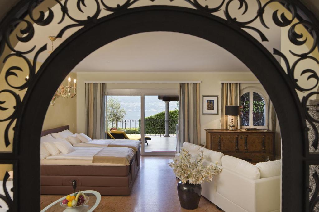 洛迦诺Boutique Hotel Albergo Brione的一间卧室设有一张床和一间客厅。
