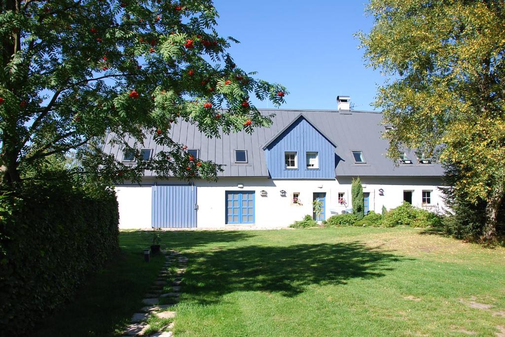 SněžnikApartment Ptačí Dům的白色谷仓,有蓝色的屋顶和院子