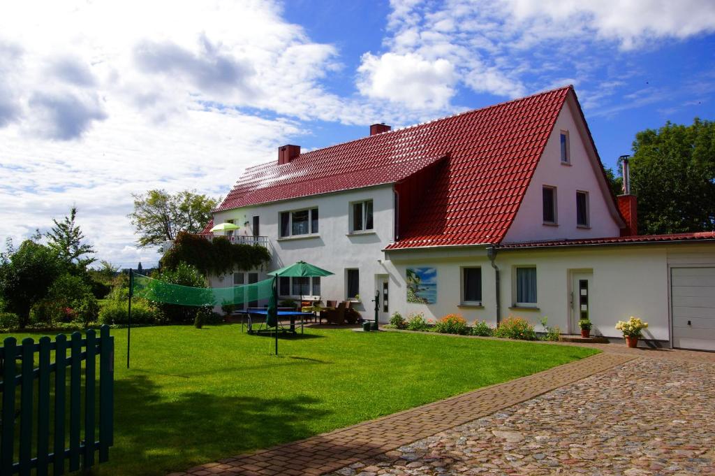 卑尔根Urlaub auf der Insel Rügen的白色的房子,有红色的屋顶和院子