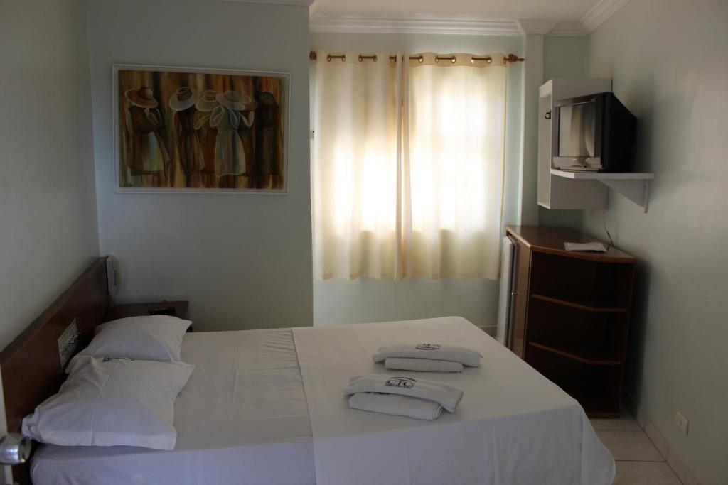 卡达斯诺瓦斯Apart Service Araras - VPC的一间卧室配有一张床,上面有两条毛巾