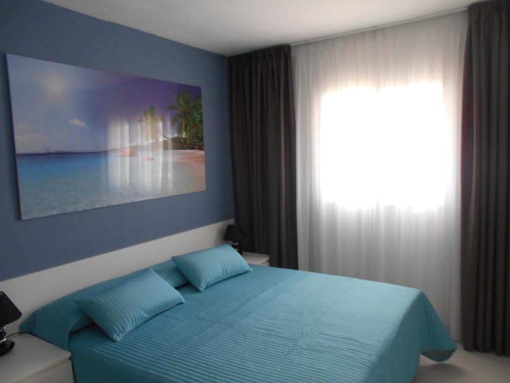 阿德耶Orlando Apart的一间卧室设有蓝色的床和窗户。