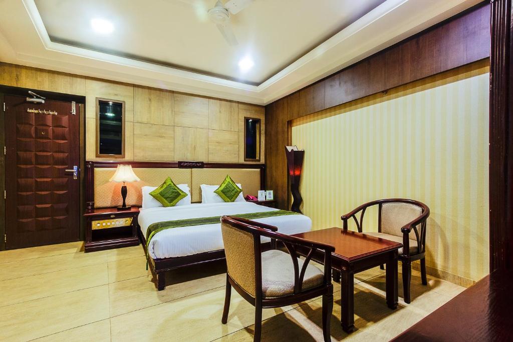 印多尔Treebo Trend Shivani的一间卧室配有一张床、一张桌子和一张桌子