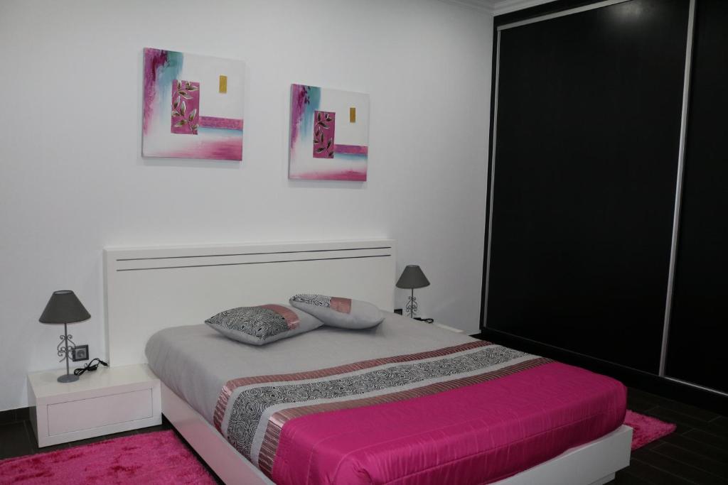 CandeláriaVivenda Paraíso的一间卧室配有一张带粉色毯子的大床