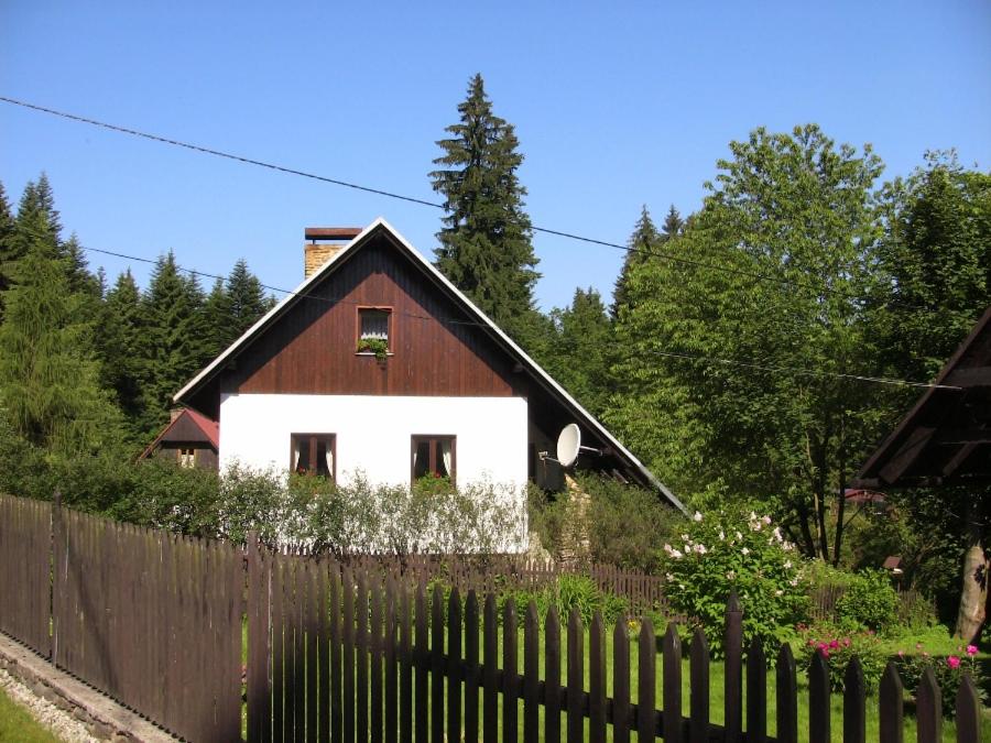 JavornáChalupa Na Bucharu的栅栏后面的一间棕色和白色的房子